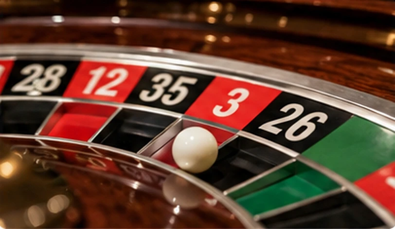 Close-up of a roulette wheel with a white ball and numbered pockets